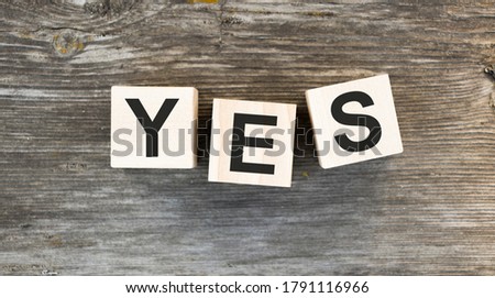 The word Yes. written in black letters on wooden blocks. Message spells Yes on white background. Business, motivation and education concept