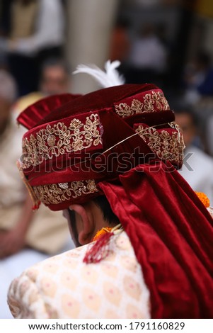 maroon turban on pedestool for groom