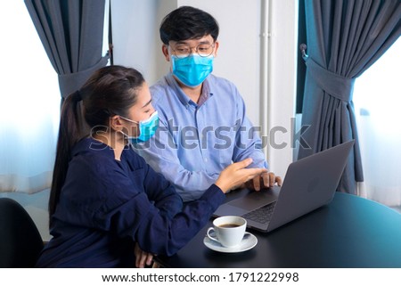 Office workers work through laptop during COVID-19 period wearing a mask