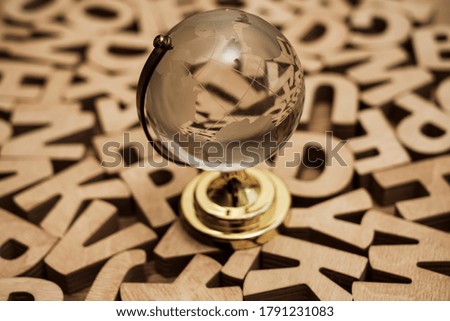 A glass globe and wooden letters around. back to school idea. transparent globe.