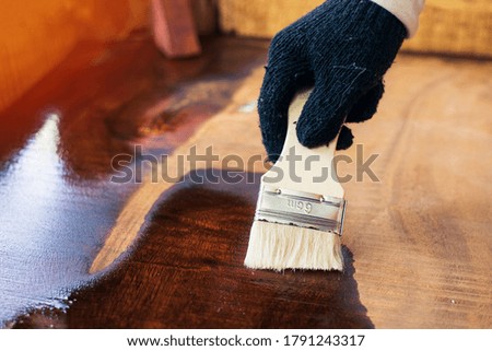 The carpenters paint the varnish with lacquer to protect the wood surface from being damaged.