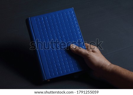 Old man hand book on dark background