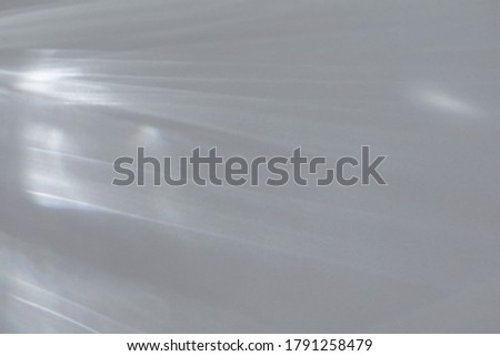 Blurred water texture overlay effect for photo and mockups. Organic drop diagonal shadow and light caustic effect on a white wall. Shadows for natural light effects Royalty-Free Stock Photo #1791258479