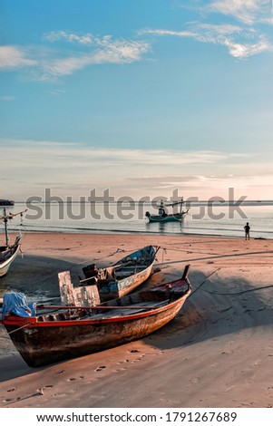 old fishing boat moored on the beach at sunset.