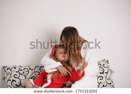 Lifestyle portrait of mom and daughter in happy home