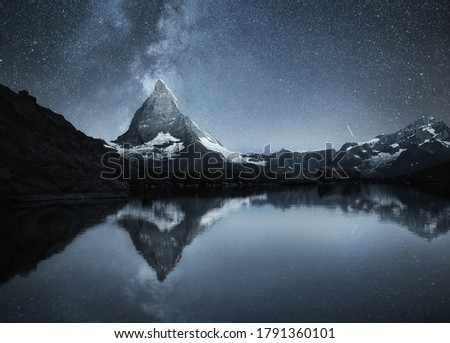 Swiss landscape. Matterhorn and reflection on the water surface at the night time. Milky way above Matterhorn, Switzerland. Travel image.  Royalty-Free Stock Photo #1791360101