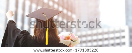 shot back side young female student in hand raising arms over fist thumb up and holding a bouquet of flowers during commencement success graduate of the university, Concept education congratulation. Royalty-Free Stock Photo #1791383228