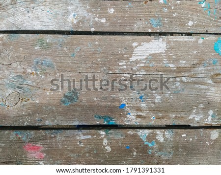 Background, texture of wooden boards in spots smeared in multi-colored paint. Photography, abstraction.