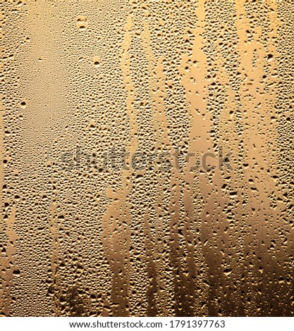 Drops of water on a glass window at dawn as an abstract background. Texture