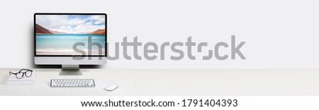 Computer with beach and ocean on screen monitor on white table Isolated in clipping path. free space on wall for text