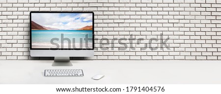 Computer with beach and ocean on screen monitor on white table Isolated in clipping path. free space on brick wall for text
