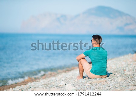 Young man on the beach relaxing with view of mountains