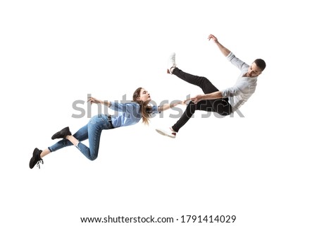 Mid-air beauty cought in moment. Full length shot of attractive young woman and man hovering in air and keeping eyes closed. Levitating in free falling, lack of gravity. Freedom, emotions, artwork Royalty-Free Stock Photo #1791414029