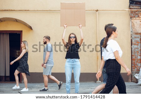 Dude with sign - woman stands protesting things that annoy her. Solo demonstration her right to talk free on the street with sign. Copyspace for text. Opinion heard by public. Social life, humor, meme