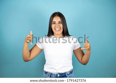 Young beautiful woman over isolated blue background shouting with crazy expression doing rock symbol with hands up