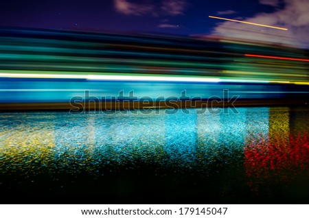 A slow shutter shot of a container ship passing by Savannah, Georgia late in the evening.