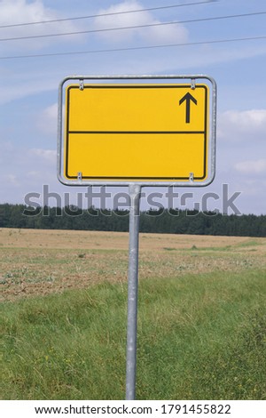 Yellow road sign with direction indicator on background