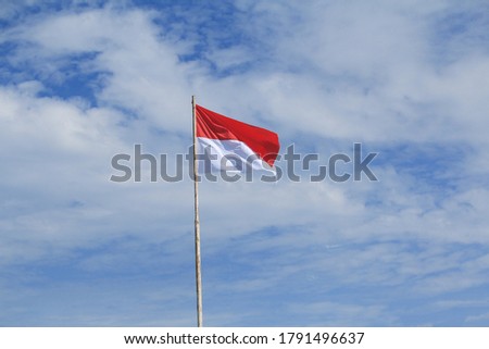 Indonesia flag on blue sky and white cloud background. 