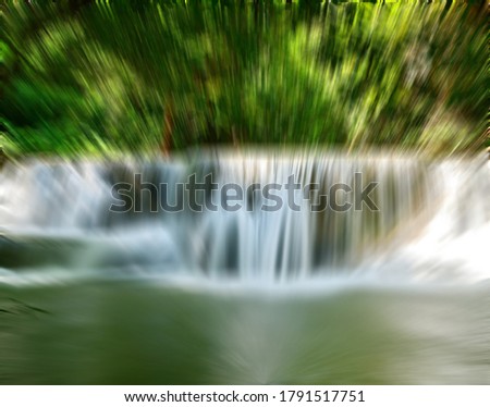 An abstract image of Beautiful waterfall natural scenery and lush jungle with zoom effect to take your eyes into the waterfall. Ideas for going on vacation in the long holiday season.