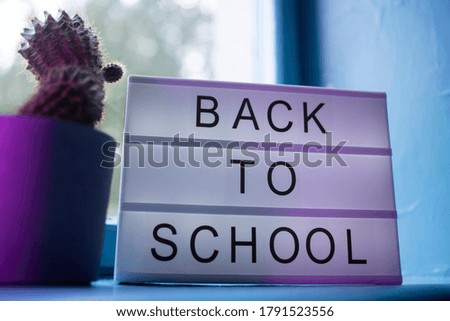 Back to school Sign on the lightbox on the window near cactus