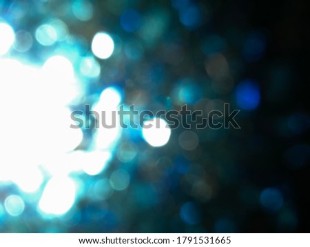 Abstract blue glitter bokeh Looks like a firework effect texture on black background. glitter vintage lights defocused elegant for cosmetics or celebrate. Sparkling magical dust particles.