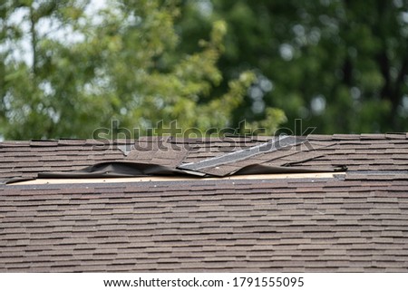 roof shingles have been damaged by high winds and strong storms Royalty-Free Stock Photo #1791555095