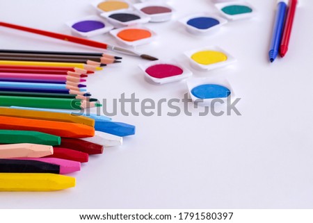 Colorful crayons and watercolor set with copy space.