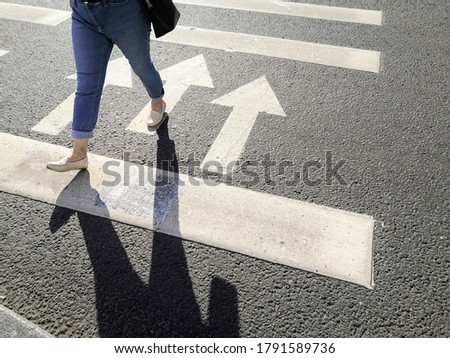 Citizen walking on pedestrian zebra crosswalk on sunny summer day