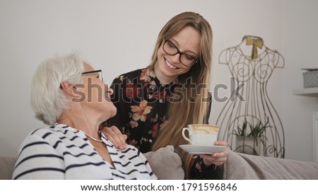 Young caucasian woman offering a tea to an elderly lady. Copy space. High quality 4k footage Royalty-Free Stock Photo #1791596846