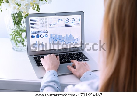 Woman using laptop in office, closeup. Fintech concept