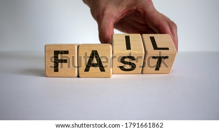 Business and design concept. Man hand flips wooden cubes with words 'fail fast' on beautiful white background, copy space. Royalty-Free Stock Photo #1791661862