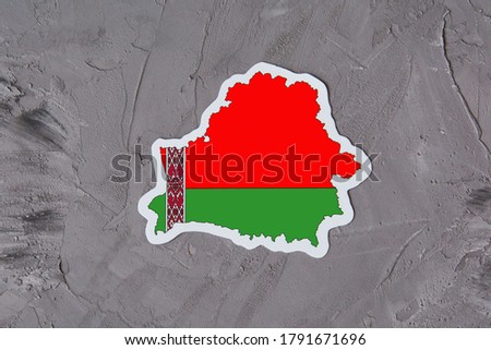Country border outline map of Belarus. Shape and national flag of the Republic of Belarus on grey concrete background. Election concept. Royalty-Free Stock Photo #1791671696