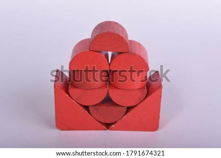 Children's creativity in the form of buildings structures and houses made of wooden geometric shapes in red on a white background