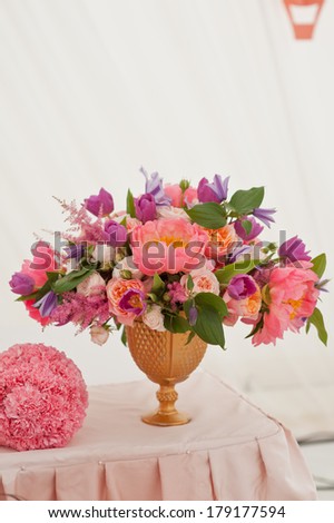 Rich bunch of peonies, tea roses, tulips, in vase on bride and groom table