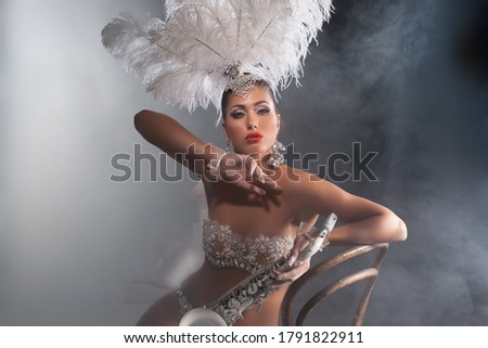 Young Beautiful woman with feather hat on a studio backround