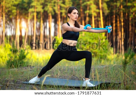 Young girl athlete performs a gymnastic exercises in nature