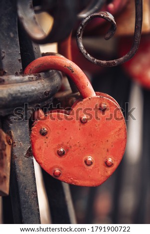  Red heart-shaped lock on a forged railing