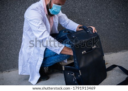 Handsome doctor with his bag on the street
