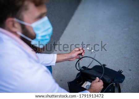 Handsome doctor with his bag on the street