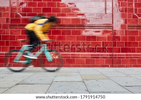 Motion blurred bike. Young afro man and his fixed bike in a suburb of London Royalty-Free Stock Photo #1791914750