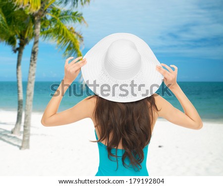 summer and vacation concept - woman sitting in swimsuit with hat