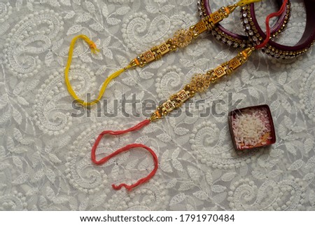 Indian festival: Raksha Bandhan background with an elegant Rakhi, Rice Grains and Kumkum. A traditional Indian wrist band which is a symbol of love between Brothers and Sisters