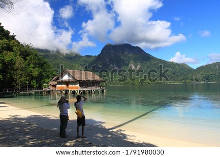Two photographers taking pictures of beautiful scenery of Ora Beach Resort, Seram island, Indonesia