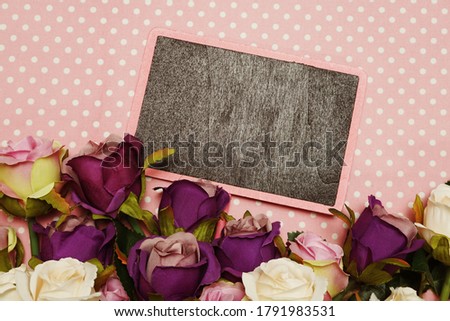 blank blackboard with Rose bouquet on pink polka dot background