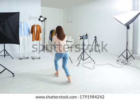 Professional photographer taking picture of ghost mannequins with modern clothes in photo studio