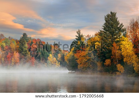 Lake fog sunrise with Autumn foliage and mountains in New England Stowe Royalty-Free Stock Photo #1792005668