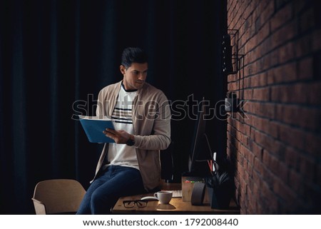 Journalist with notebook at workplace in office