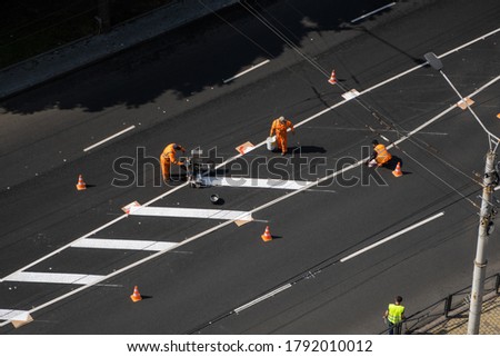 UKRAINE, KYIV - May 25, 2020: Road workers painting marking white line on the road surface. Thermoplastic spray marking machine during road construction.