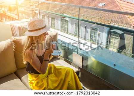 Young traveler woman with smartphone sitting cafe in Lisbon and takes pictures of the city.