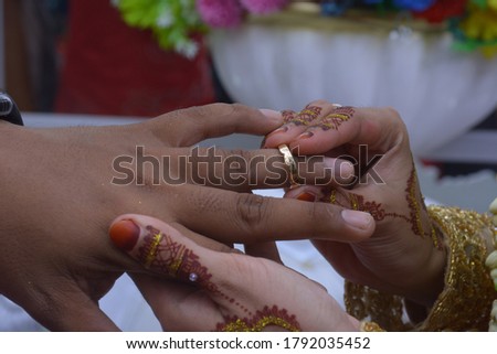 the wedding couple's hand that puts the ring on the finger. Engagement concept.
